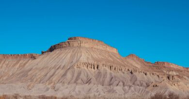 Scenic view of a mesa in Utah's desert with clear blue sky, perfect for landscape photography.