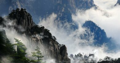 Misty mountain peaks of Huangshan, China enveloped in fog, creating a serene and dramatic landscape.