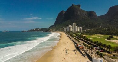 Stunning aerial view of Praia da Barra, Rio de Janeiro, featuring lush mountains and sandy shores.