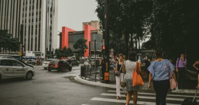 Dynamic urban street scene in Sao Paulo with pedestrians crossing and lively city traffic.