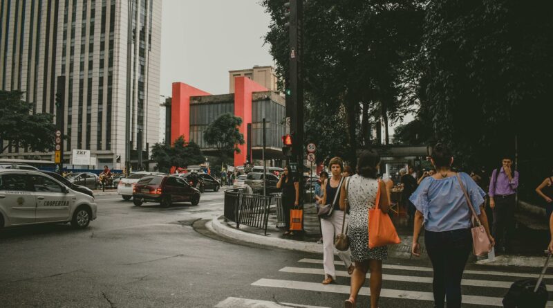 Dynamic urban street scene in Sao Paulo with pedestrians crossing and lively city traffic.
