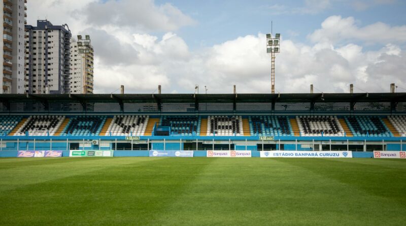 Empty Estádio Banpará Curuzu in Belém, Brazil with green grass and clear sky.