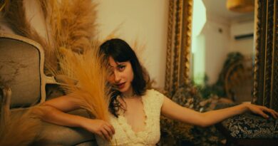 Elegant woman in vintage setting with dried plants, reflecting a warm, relaxed mood.