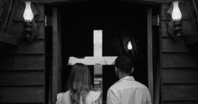 Couple seen from behind entering a church with a cross in Paragominas, Brazil.