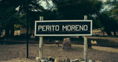 A classic wooden sign for Perito Moreno, captured in a rural setting in Argentina.