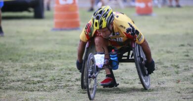 Determined wheelchair racer competing in an outdoor marathon, displaying focus and athleticism.