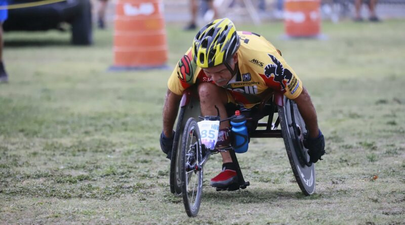 Determined wheelchair racer competing in an outdoor marathon, displaying focus and athleticism.
