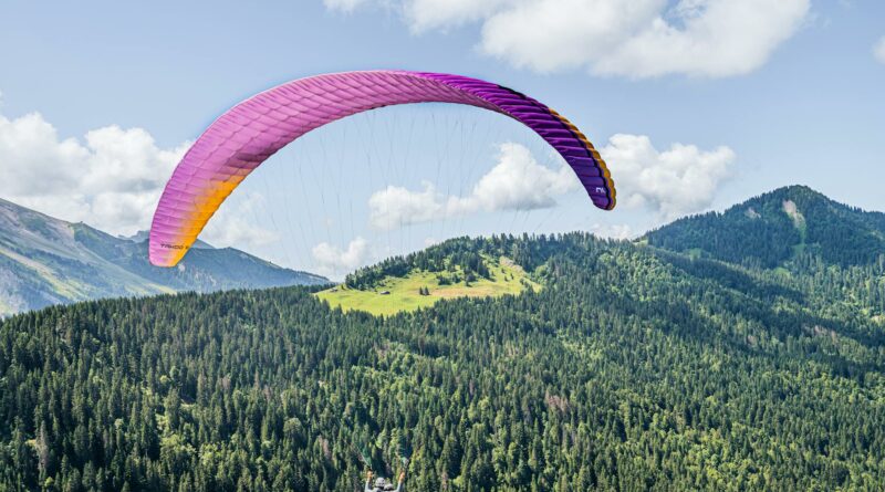 Experience an adventurous paragliding flight over lush alpine landscapes under a vibrant sky.