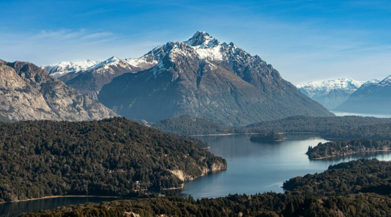 A breathtaking view of the Andes Mountains and Lake Nahuel Huapi, Argentina, under a clear blue sky.