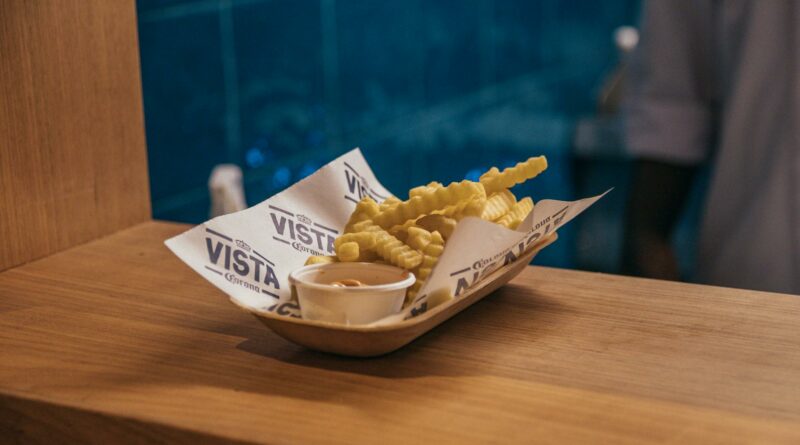 Delicious crispy french fries served with dip on a wooden surface at a São Paulo restaurant.