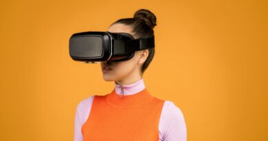 A woman enjoying virtual reality immersion with a VR headset against a vibrant orange background.