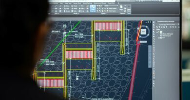 A civil engineer working on a weir design using CAD software on a computer screen in an office setting.