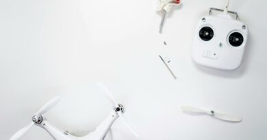 A flat lay of a drone kit including a controller and spare propellers on a white background.