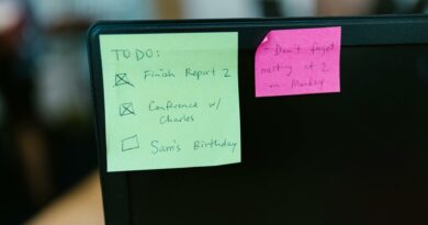Colorful sticky notes with reminders and to-do list on an office monitor.