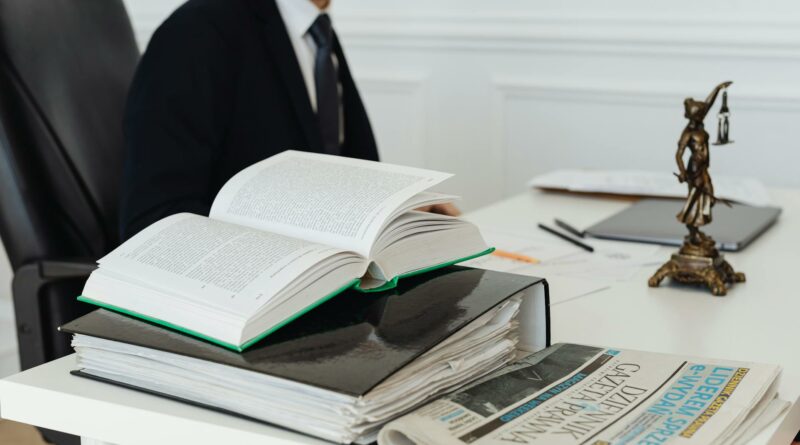 A lawyer sitting at a desk with legal books, documents, and a newspaper, embodying professionalism.