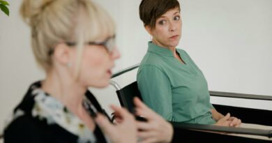 Two women engaged in a focused conversation indoors with contrasting attire.