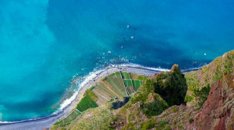 Stunning aerial shot of Câmara De Lobos coastline, Madeira, showcasing vibrant ocean and rugged landscape.