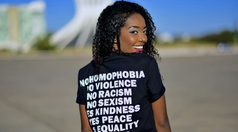 Portrait of a woman in DF, Brazil, promoting equality with positive messages on her shirt.