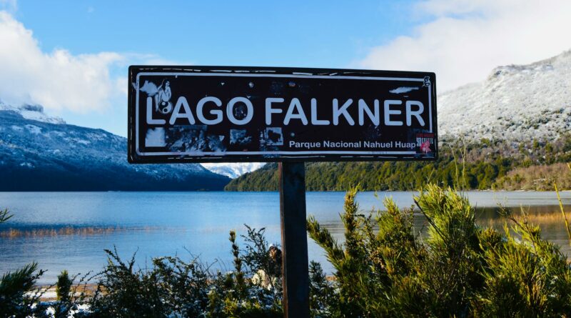 A serene view of Lago Falkner in Parque Nacional Nahuel Huapi, Argentina, with snow-capped mountains.