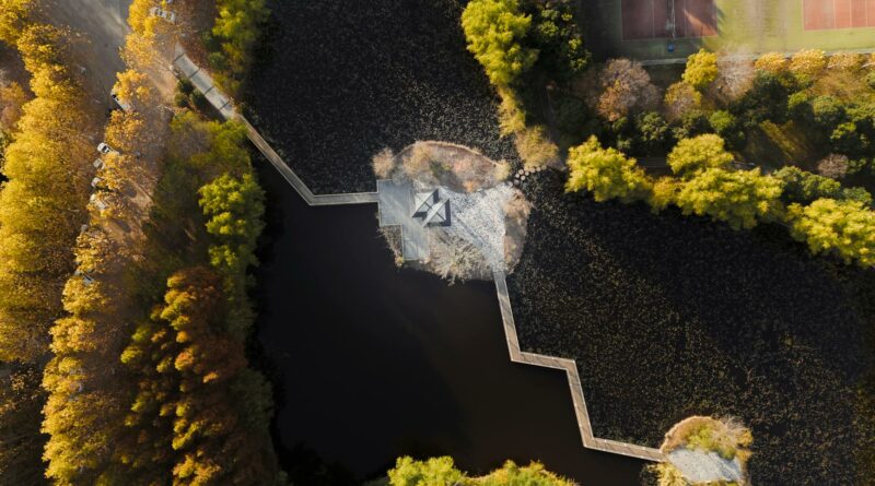 Stunning aerial shot of a park in Nanjing, Jiangsu, China, showcasing a water feature and tennis courts.