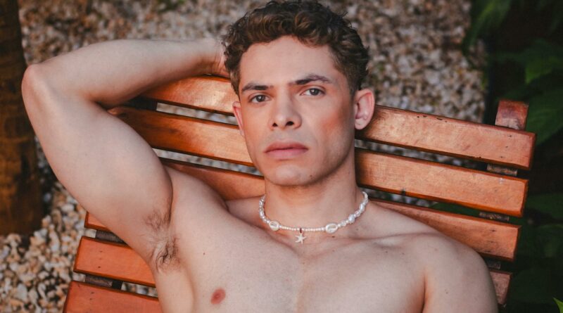 A man relaxes outdoors on a wooden chair in São Paulo, Brazil, showcasing serene elegance and style.