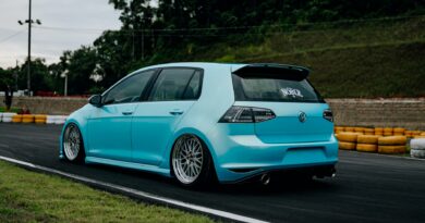 A stanced blue VW Golf parked on a race track in Brazil, showcasing aftermarket modifications.
