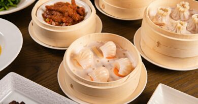 Delicious assortment of dim sum served in bamboo steamers on a wooden table.