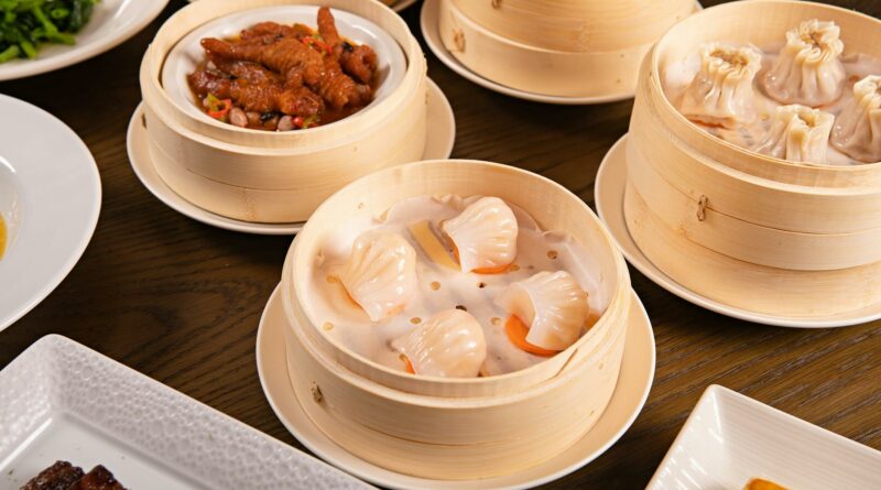 Delicious assortment of dim sum served in bamboo steamers on a wooden table.
