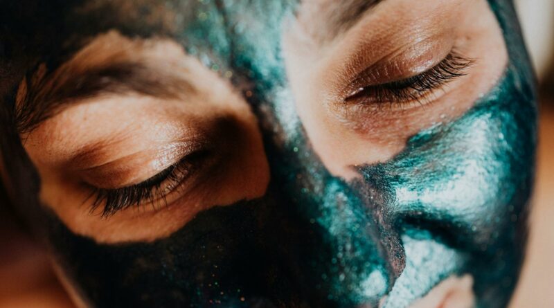 Serene close-up of closed eyes during a colorful facial mask treatment, highlighting relaxation and skincare.