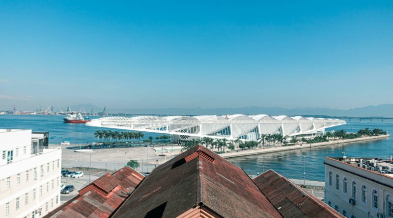 A breathtaking aerial view of the Museum of Tomorrow and waterfront in Rio de Janeiro under a clear blue sky.