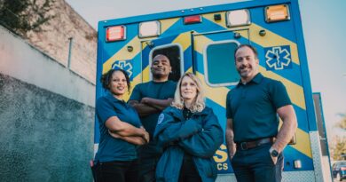 Paramedic team stands confidently in front of an ambulance, ready for emergencies.