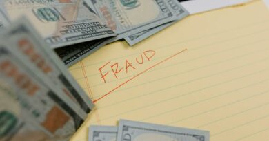Close-up of US dollars and 'Fraud' written on yellow paper, representing financial scams.