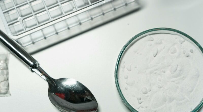 Metal spoon and white powder on a white countertop, suggesting substance use.