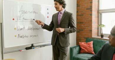 Businessman presenting a whiteboard agenda on VR training in modern office meeting.