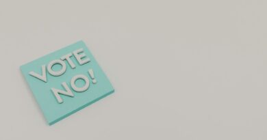 A blue sticky note displaying the message 'Vote No!' on a white surface, minimalistic and impactful.
