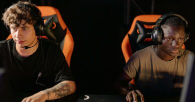 Two focused gamers wearing headsets in a cyber cafe, engaged in a competitive online match.