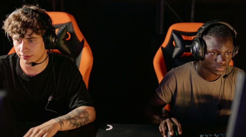 Two focused gamers wearing headsets in a cyber cafe, engaged in a competitive online match.