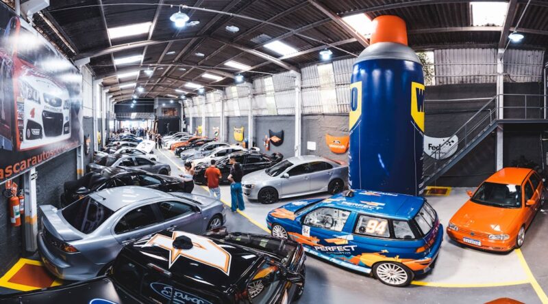 A bustling indoor car meet in Vila Nair, showcasing a range of modified cars and auto enthusiasts.
