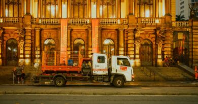 Front view of the Municipal Theatre in São Paulo, Brazil, illuminated at night with an urban cleaning truck parked in front.
