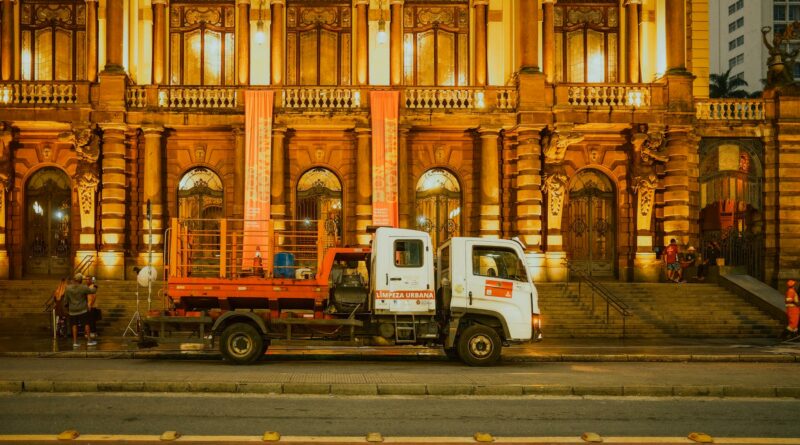Front view of the Municipal Theatre in São Paulo, Brazil, illuminated at night with an urban cleaning truck parked in front.