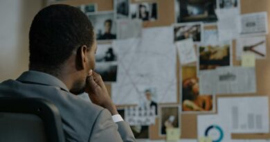 A detective deep in thought, analyzing a crime investigation board filled with photos and notes.
