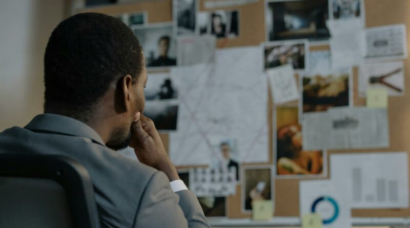 A detective deep in thought, analyzing a crime investigation board filled with photos and notes.