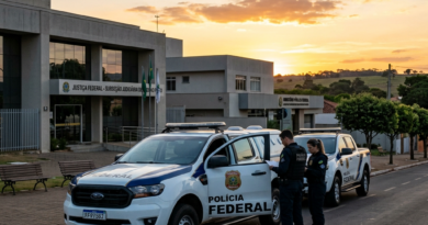 Two Federal Police officers standing by vehicles outside a judicial building during sunset.