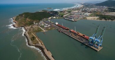 Caminhões e navios em um porto brasileiro, simbolizando a infraestrutura logística do país