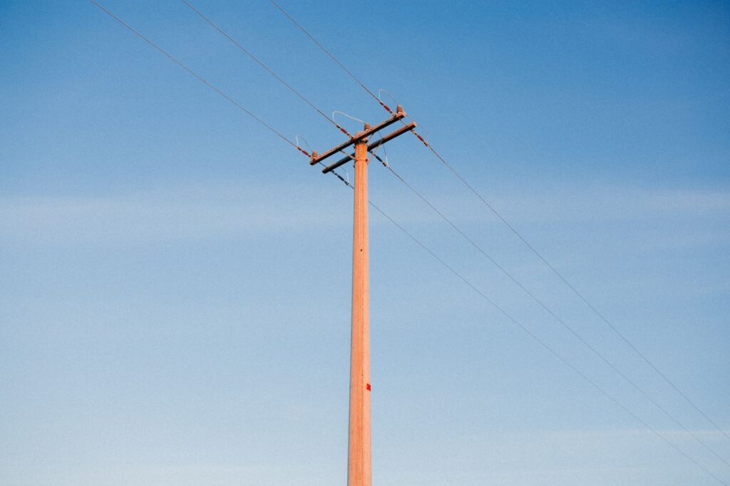 Linhas de transmissão de energia elétrica no Brasil ao pôr do sol, simbolizando a infraestrutura da rede e os desafios futuros