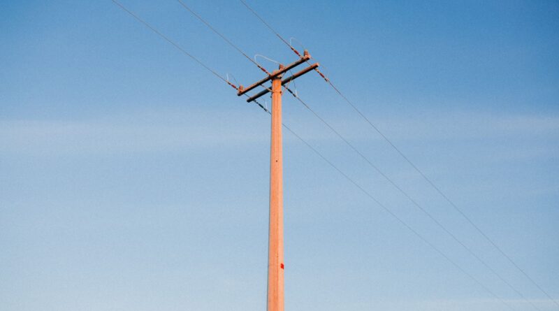 Linhas de transmissão de energia elétrica no Brasil ao pôr do sol, simbolizando a infraestrutura da rede e os desafios futuros