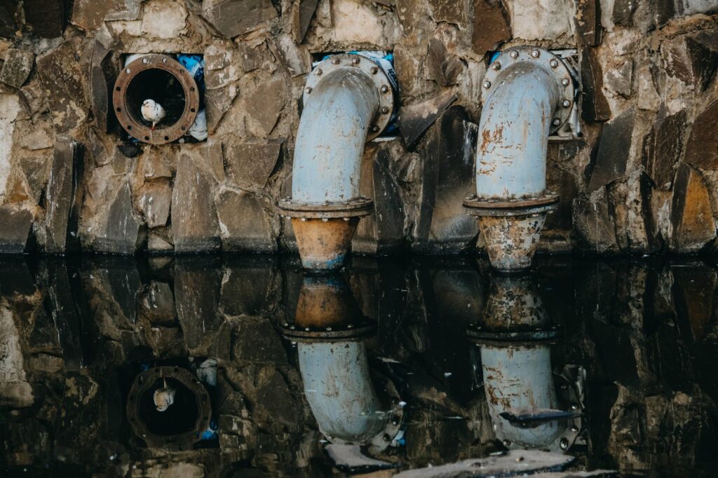 Trabalhadores em obras de saneamento básico, instalando tubulações em uma área urbana no Brasil