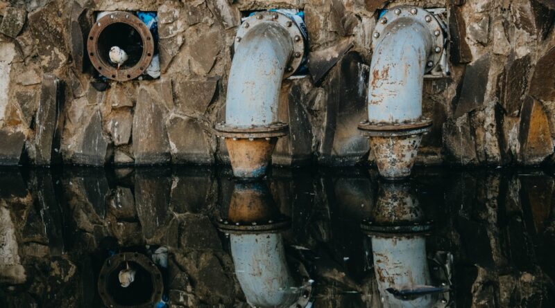 Trabalhadores em obras de saneamento básico, instalando tubulações em uma área urbana no Brasil