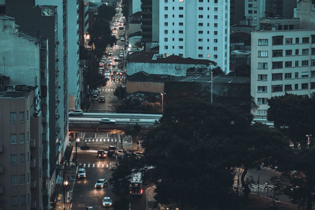 Vista aérea de um congestionamento de trânsito em uma grande cidade brasileira, com carros parados e alguns ônibus, simbolizando os desafios da mobilidade urbana.