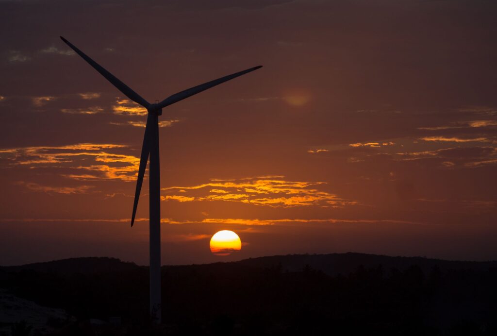 Painéis solares e turbinas eólicas em paisagem brasileira, simbolizando a transição energética.